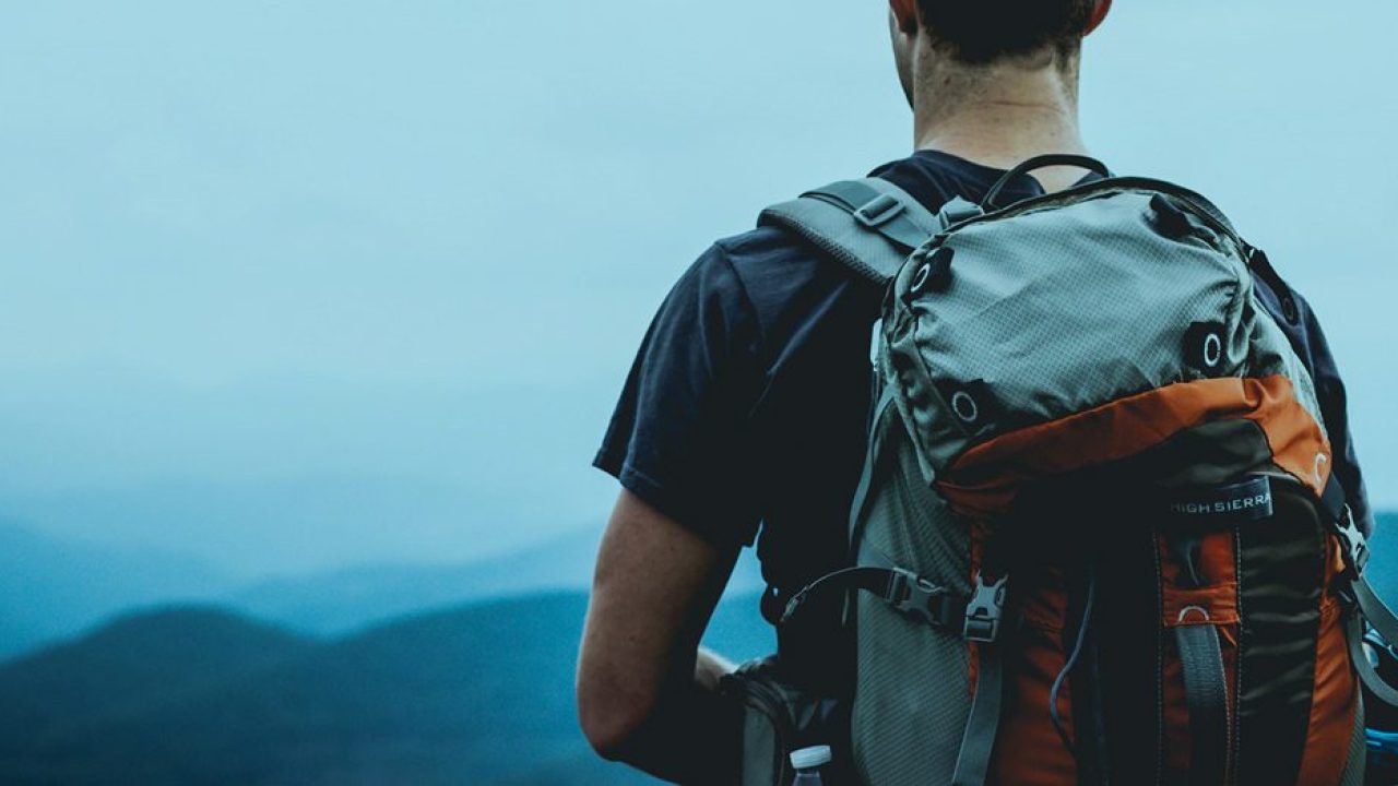 guy with backpack looking out into distance